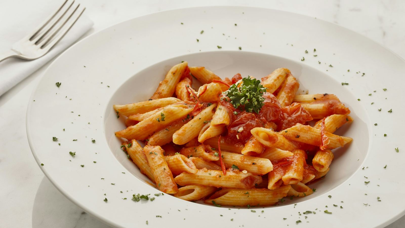 A plate of penne in tomato sauce