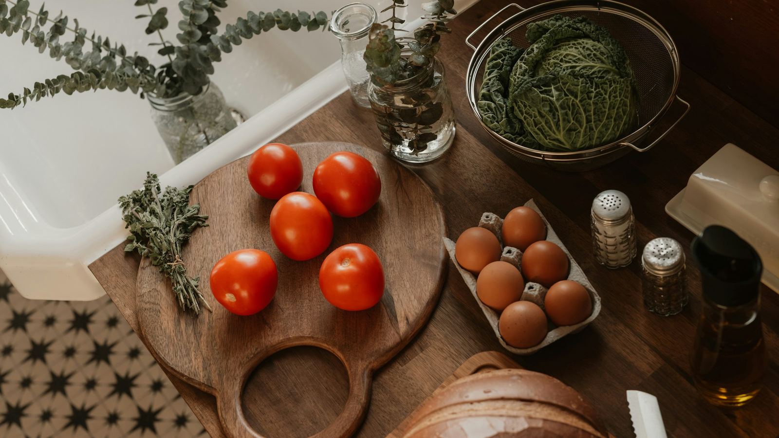 Tomatoes, eggs and a cabbage on a kitchen counter